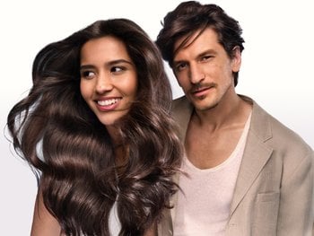 A woman with long dark brown hair and a man with similar hair color and style.