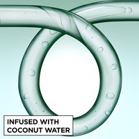 Close-up of a glass curl-shaped tube infused with coconut water bubbles, representing the hydrating ingredients in Garnier Fructis Curl Construct Creation Mousse.