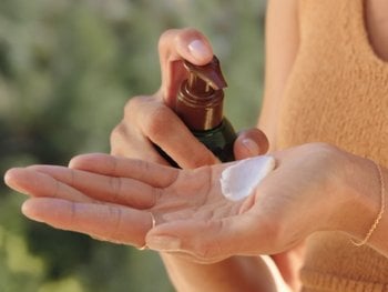Applying avocado oil as a leave-in conditioner, demonstrating its use for soft and manageable hair.