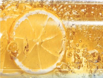 An orange slice submerged in a liquid, representing the natural source of vitamin C and its benefits for hair and scalp health.