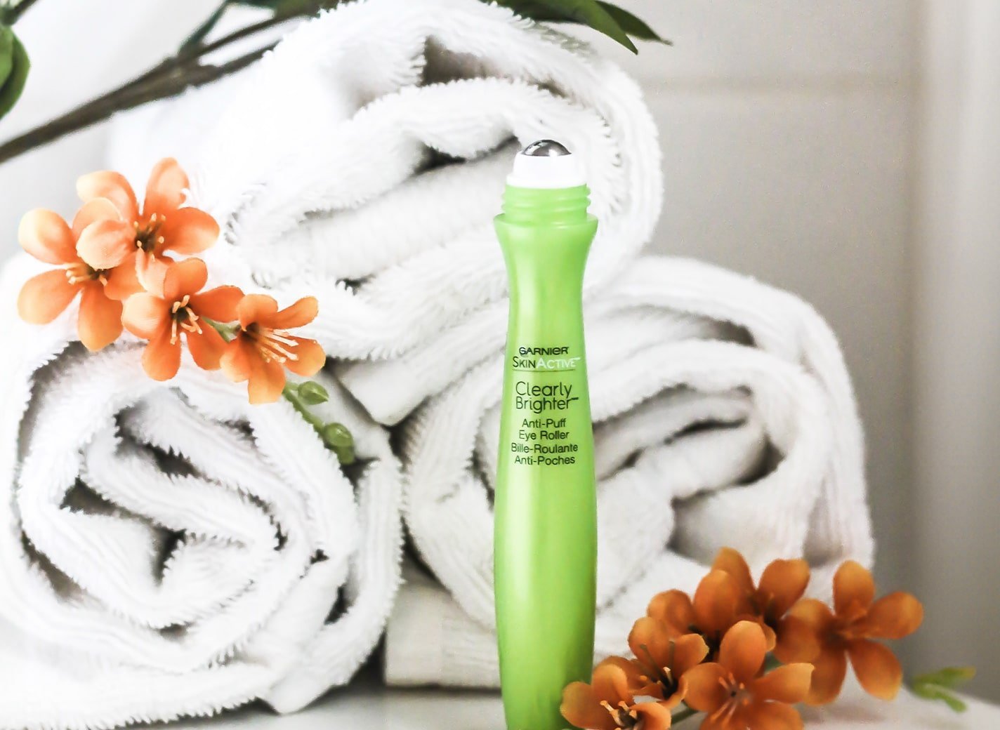Garnier brightening eye rollers with towels and flowers