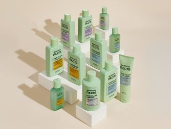 A group of green Garnier Fructis hair product bottles are displayed.
