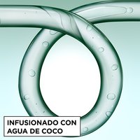 Close-up of a glass curl-shaped tube infused with coconut water bubbles, representing the hydrating ingredients in Garnier Fructis Curl Construct Creation Mousse.