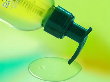 A bottle of Garnier Sleek & Shine anti-frizz serum dispensing product. This serum creates a protective barrier to block humidity and keep your hair sleek and polished.