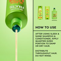 Close-up of a bottle of Garnier Fructis Sleek & Shine Leave-In Conditioner dispensing product on the left side. "How to use" section on the right side say: "After using Sleek & Shine shampoo and conditioner, apply quarter-sized portion to damp or dry hair. Distribute throughout hair. Do not rinse.". Featured products are shown at the top.
