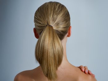 The back of a woman's head showcases a neatly styled high ponytail.
